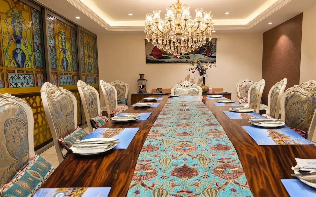 The Ottoman Room: one long wooden table with carved chairs, a chandelier overhead and stained-glass panels along the wall