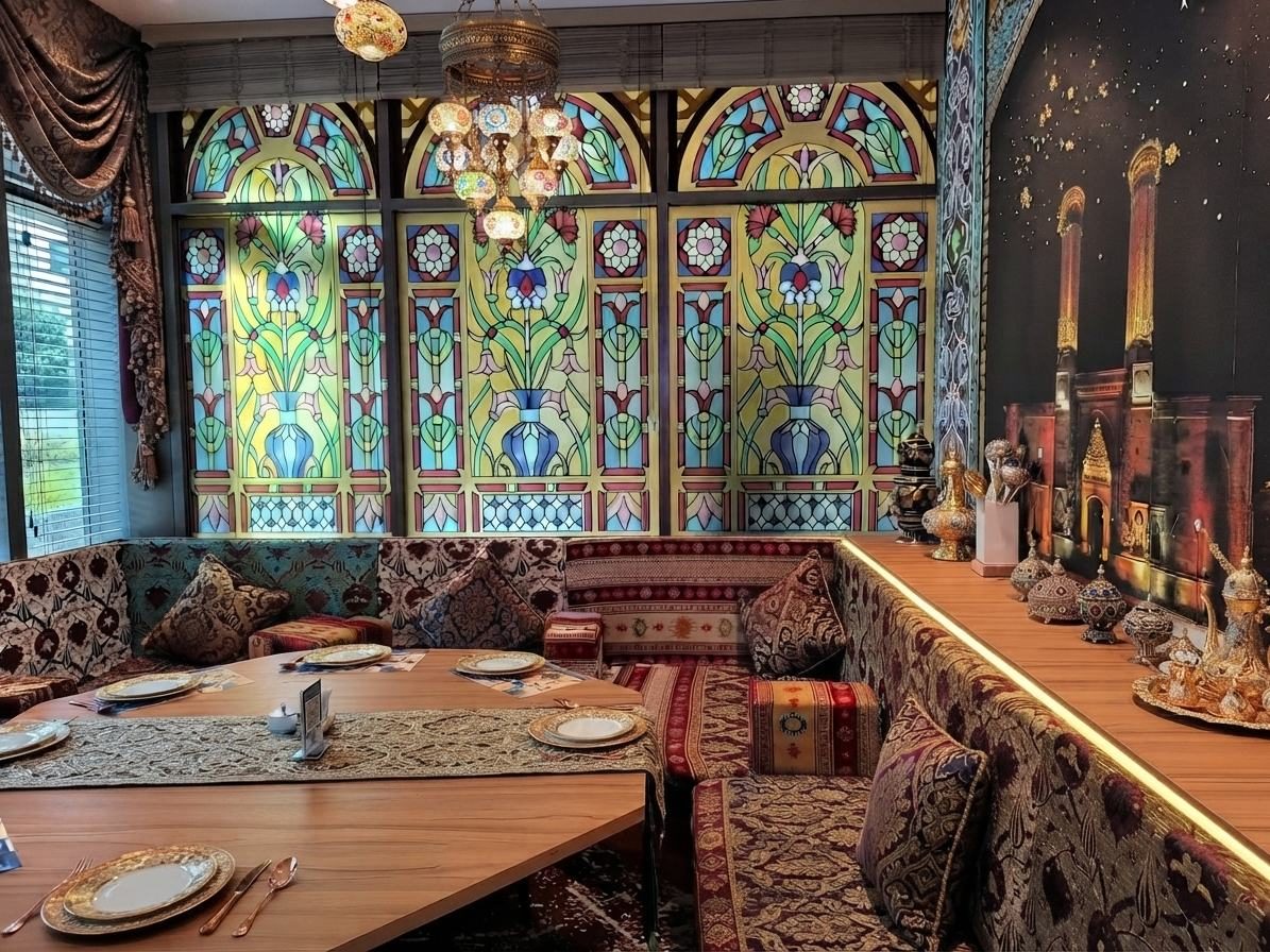 The Seljuk Room: low cushioned banquettes in kilim and velvet beneath stained-glass windows, with Turkish lanterns above